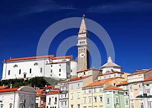 The belltower of St. George`s Church and The Franciscan monastery nearby, seen from the Tartini Square in Piran