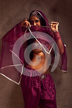 Belly-dancer woman in afghani pants, purdah and adornment