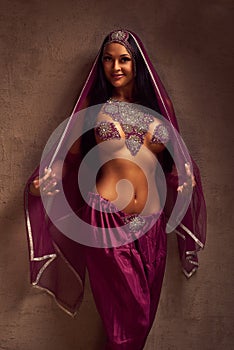 Belly-dancer woman in afghani pants, purdah and adornment