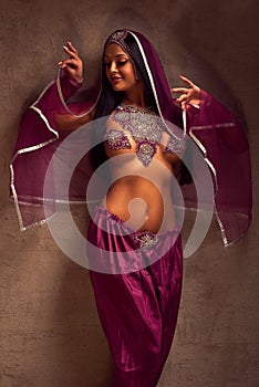 Belly-dancer woman in afghani pants, purdah and adornment