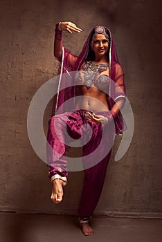 Belly-dancer woman in afghani pants, purdah and adornment