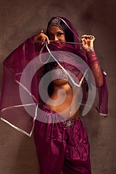 Belly-dancer woman in afghani pants, purdah and adornment photo