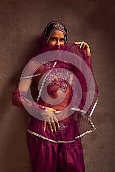 Belly-dancer woman in afghani pants, purdah and adornment photo