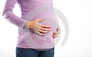 The belly of a pregnant girl which she holds with her hands on a white background, isolate. Abdominal bloating in