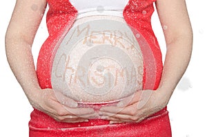 Belly of a pregnant woman with a Christmas greeting