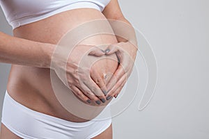Belly of a pregnant woman isolated on white background