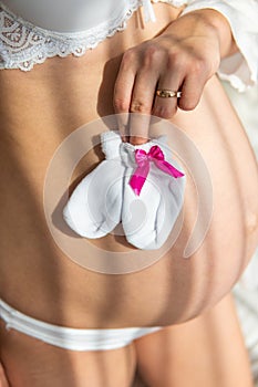 Belly of pregnant woman over white background, Pregnant girl. Image of pregnant woman touching her belly with hands