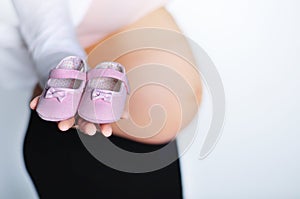 Pregnant woman with little shoes in her hand photo