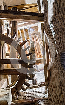 From below shot of aged water mill turning inside weathered mill building