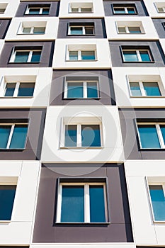 From below shot of modern and new apartment building. Photo of a tall block of flats against a sky.