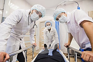 Below view of surgeons holding medical instruments in hands and looking at patient