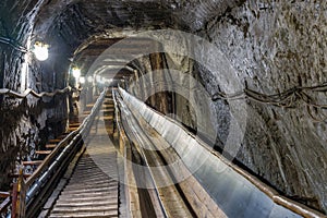 Belt conveyot in illuminated underground tunnel