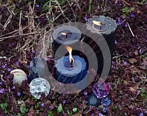 Beltane magic ritual with burning candles, crystals and magic objects outside