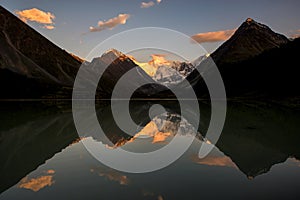 Belukha peak at sunset is reflected in the mountain lake AK-Kem
