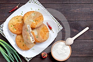 Belyashi - deep-fried meat pies. Patties on a plate on a wooden background