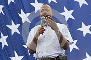 Ben Carson close up in front of a US flag stars, August 2015