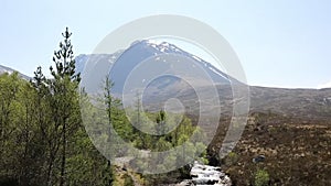 Ben Nevis Scotland UK snow topped mountain in summer with mountain stream in foreground, Lochaber Scottish Highlands