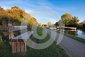 Bench alongside a canal towpath in autumn photo