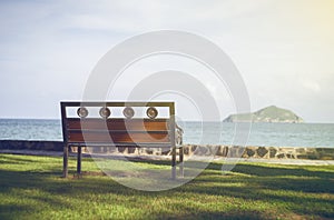 A bench with blurred blue sea and sky in background.Secluded place for near the sea shore.lonely concept.selective focus.