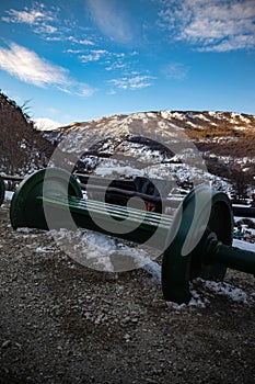 Bench with cannon wheels with the hills covered in snow in the background