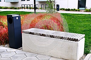 Bench and garbage bin in garden of nodern residential district