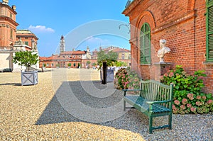 Bench on gravel next to brick house in Piedmont, Italy.