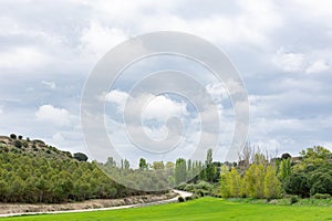 Bench on green field surrounded by trees: Castilian landscape in spring