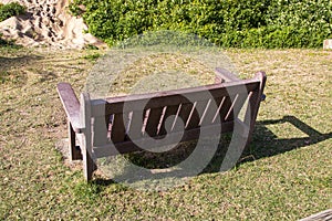 Bench on Green Grass at Edge of Sea Sand