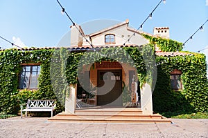 bench by the large beautiful country house braided with ivy