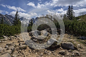 A bench on a mountain trail with a view of the peaks. The Tatra Mountains, the Gasienicowa Valley area