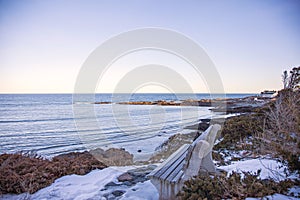 Bench n Marginal Way path along the rocky coast of Maine in Ogunquit during winter photo