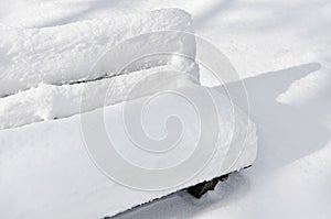 Bench in a park covered completely by snow