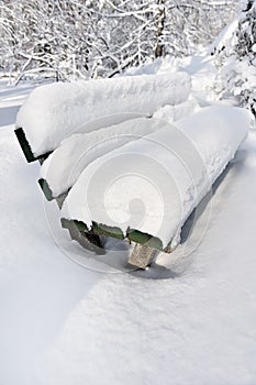 Bench in a park covered completely by snow