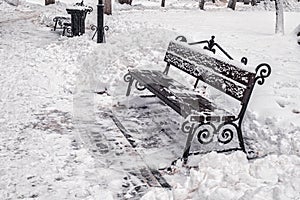 A bench in the park covered with snow in winter