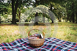 A bench in a park. wicker picnic basket blanket park