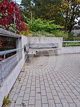 Bench at the public park. Modern recreation place. Pathway in perspective. Concrete and timber in modern architecture