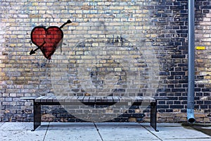 Bench and a rain pipe in a dark corner heart on the wall