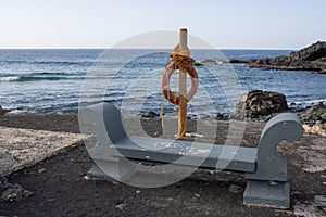 Bench, rescue wheel and Atlantic ocean