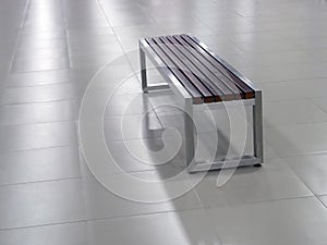 Bench with steel frame and wooden seat elements on the tile floor