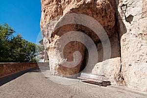 Bench under a rock, houses hung (casas colgadas) in Cuenca, Cast