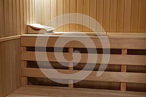 Bench and walls in a small home sauna sheathed with clapboard from  natural linden wood