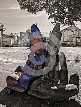 Bench in wood made up by two hands holding a butterfly, located in port Alberni at Victoria Island