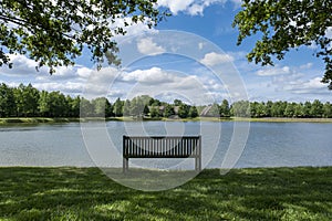 Benche front of lake in city park with blue sky landscape in summer park bench, beautiful garden bench, concept of rest, nobody in