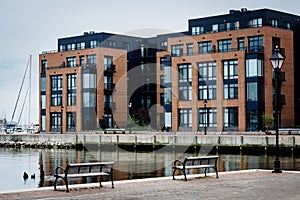 Benches and apartment building on the waterfront in Fells Point, Baltimore, Maryland.