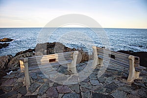 Benches on Marginal Way path along the rocky coast of Maine in Ogunquit during winter