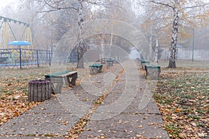 Benches in an old abandoned amusement park on a foggy autumn morning