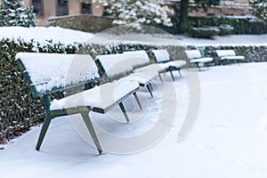 Benches under the snow in a public park in winter
