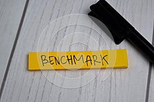 Benchmark write on sticky notes isolated on office desk