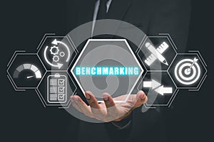 Businessman hand holding benchmarking icon on virtual screen photo