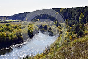 Bend of the Iren river near a high and rocky bank. Sunny autumn in the foothills of the Western Urals.